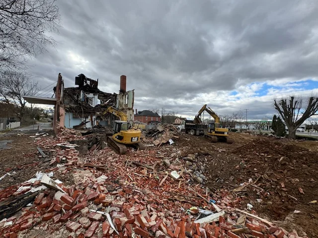 Two excavators demolishing a building on site