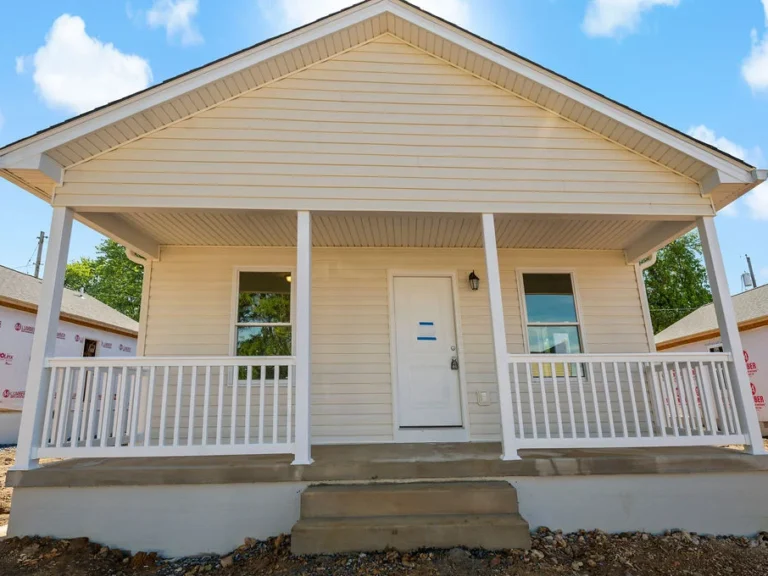 Exterior view of a custom-built light yellow and white house